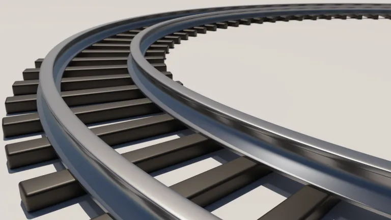 A curved section of train track from a low perspective close to the tracks, with shallow depth of field.